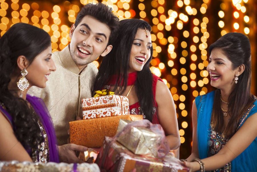 Indian family exchanging Diwali gifts and sweets