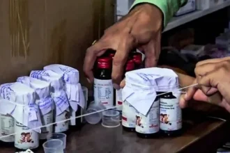 Doctors examine patients affected by toxic cough syrup in a government hospital