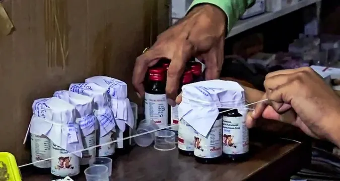 Doctors examine patients affected by toxic cough syrup in a government hospital