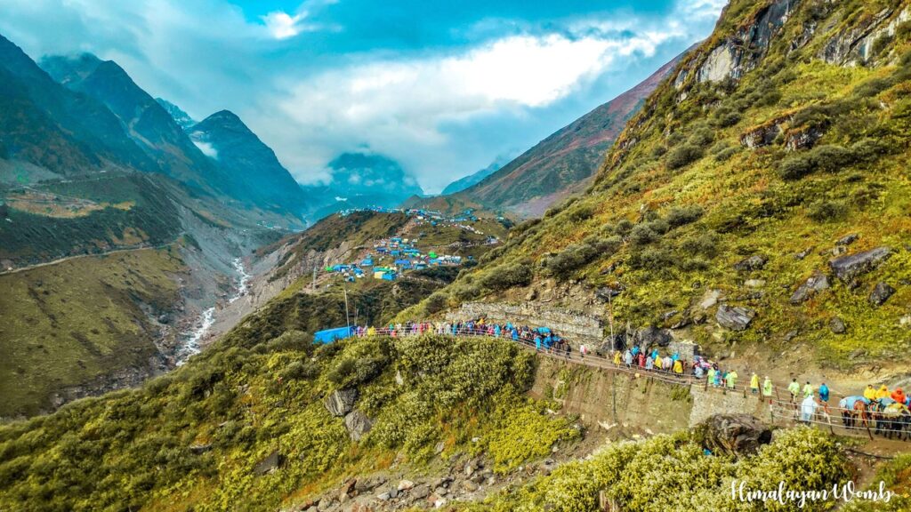 Mountain trekking path leading to Kedarnath Temple with pilgrims.
