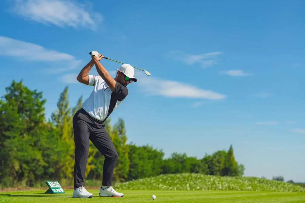 Golfer swinging on a lush green golf course symbolizing fitness and focus