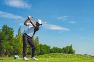 Golfer swinging on a lush green golf course symbolizing fitness and focus