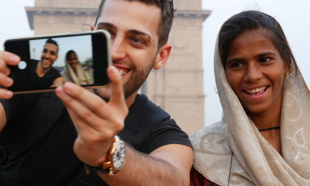 A young traveler helping a local vendor at a street market, symbolizing kindness and emotional connection through travel.