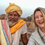 Travelers sharing stories and meals with locals in a rural village, representing empathy and cultural exchange through travel.