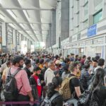 Passengers waiting in long queues at an Indian airport due to IndiGo flight delays and cancellations.