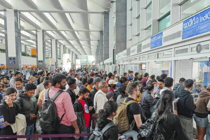 Passengers waiting in long queues at an Indian airport due to IndiGo flight delays and cancellations.