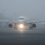Dense winter fog reducing visibility at an Indian airport runway, causing flight delays
