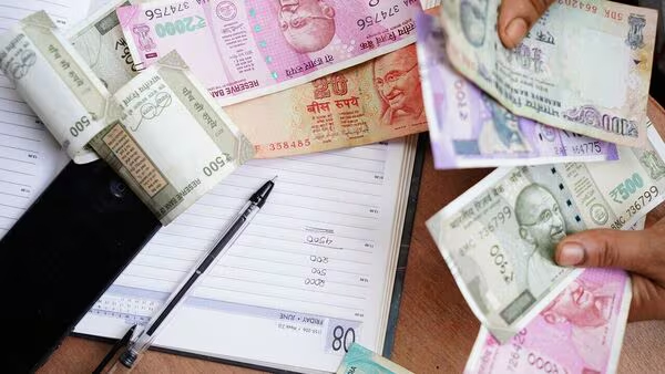 Bills, calculator, and loan papers showing EMI burden on middle-class Indians